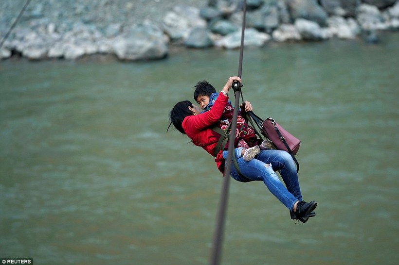 Через відсутність мосту жителі китайської села щодня перетинають річку на тросах